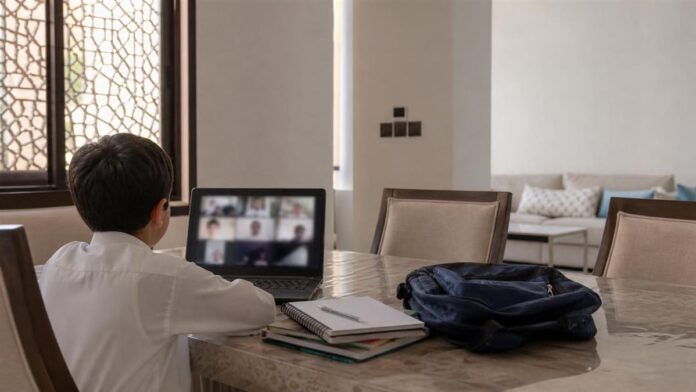 Saudi student at home attending a live online class on a laptop during a distance learning day